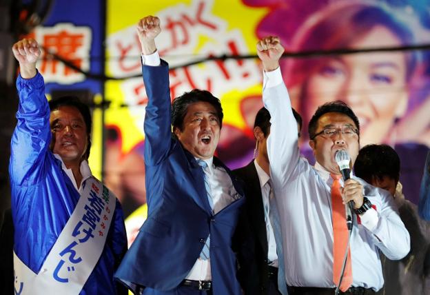 El primer ministro japonés, en el centro de la imagen, se muestra eufórico tras pronunciar un discurso en Tokio. :: Kim Kyung-Hoon / reuters
