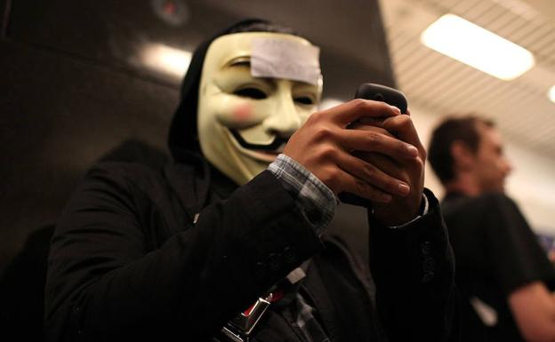 Una persona con una careta de 'V de Vendetta'.