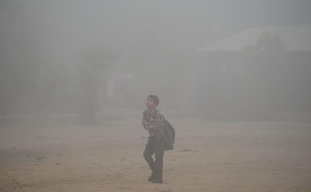 Un niño, yendo a la escuela en Nueva Delhi.