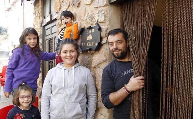 Ramón Barragán, en la puerta de su bar con unos niños. 