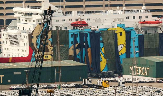 El barco atracado en Barcelona con los personajes de Warner ocultos tras lonas y en el que se aloja parte del despliegue. :: Albert Gea / REuters