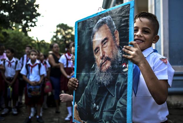 Un niño sostiene un retrato de Fidel Castro durante un acto en una escuela primaria en La Habana. :: Alejandro Ernesto / efe
