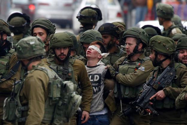 Soldados israelíes detienen a un manifestante durante unas protestas en la ciudad cisjordana de Hebrón. :: Abed Al Hashlamoun / efe
