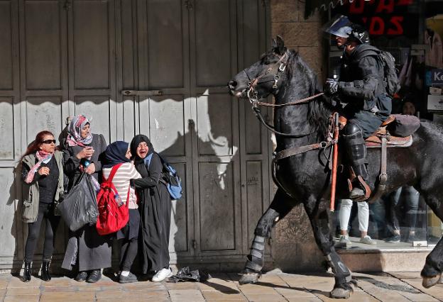 Un grupo de mujeres se asusta ante la presencia de un agente israelí a caballo. :: ahamad gharabli / afp
