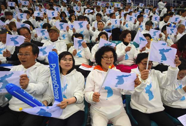 Aficionados animan a deportistas norcoreanas con banderas unificadas durante una competición hace un año. :: JUNG Yeon-Je/ afp