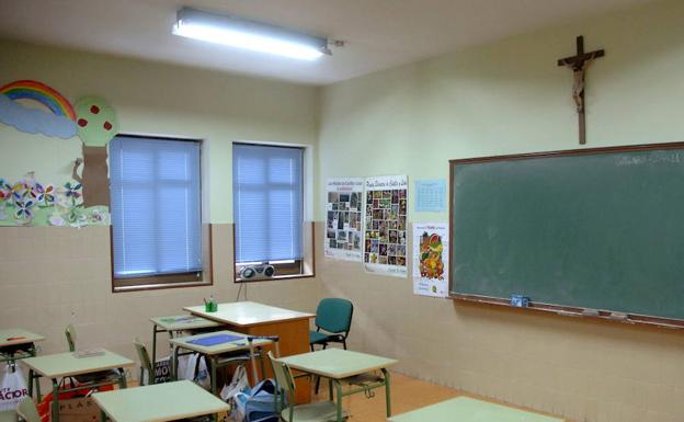 Aula escolar con un crucifijo. 