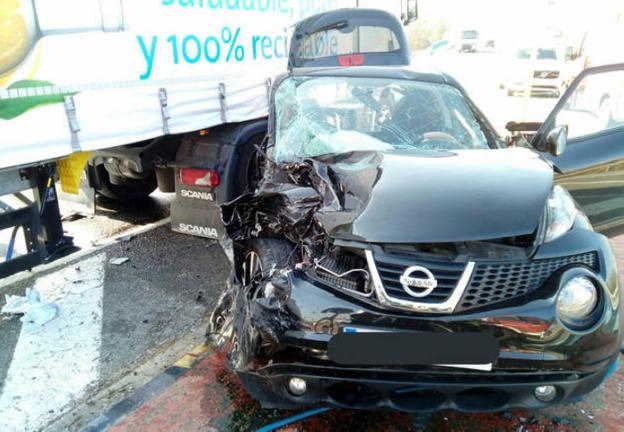 Estado en que quedó el coche en el que viajaban las mujeres y, detrás, el camión. :: bomberos de navarra