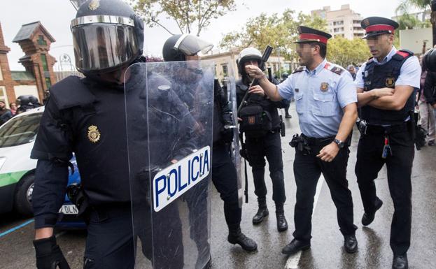 Un mosso se encara con un policía nacional, frente a un colegio electoral de Hospitalet durante la jornada del 1-O.