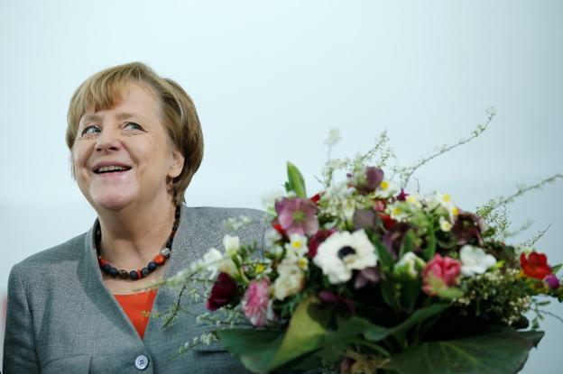 Merkel es obsequiada con un ramo de flores en vísperas del día de San Valentín. :: Axel Schmidt / REUTERS
