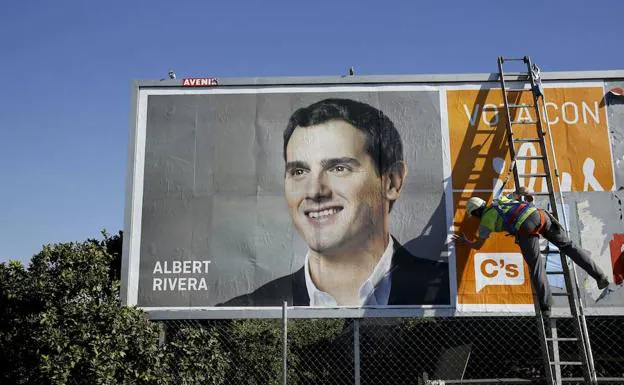 Un operario coloca un cartel de Albert Rivera, en la localidad sevillana de Gelves, con motivo de las elecciones generales de 2015. 