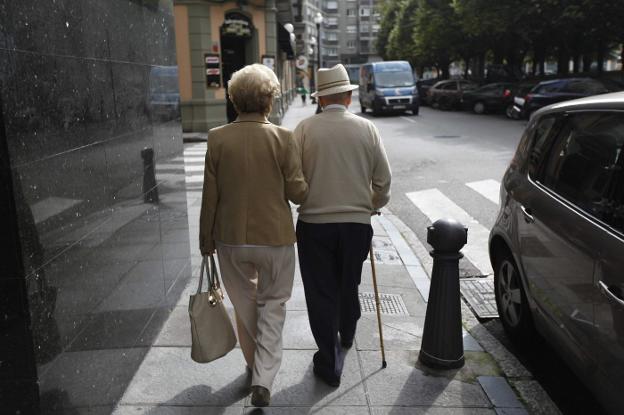 Una pareja de jubilados pasea por una calle de Bilbao. :: J. peteiro