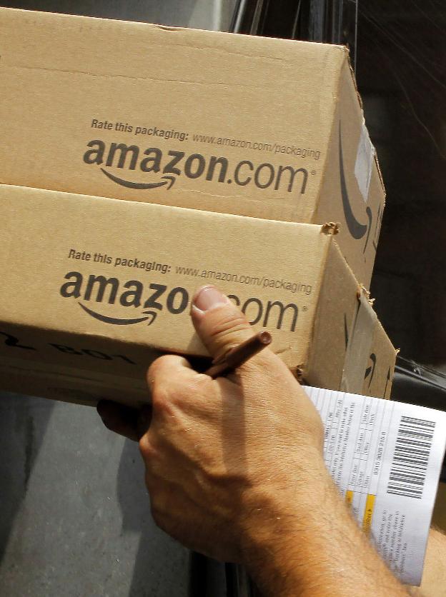 Un trabajador de Amazon lleva varios paquetes solicitados por clientes. :: BRIAN SNYDER / reuters