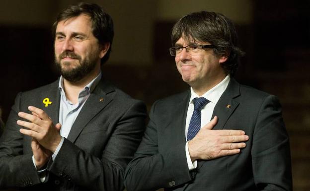 El exconsejero Comin y Carles Puigdemont agradecen los aplausos durante un acto independentista en Bruselas.