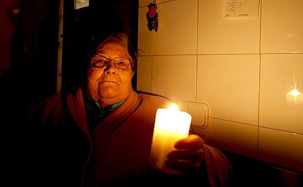 Una vecina de Ortigosa se las igenia con unas velas durante un apagón en el año 2013.