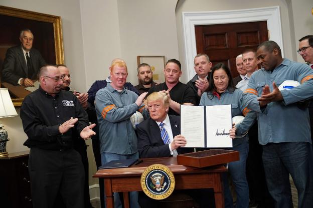 Donald Trump firma, ayer, los aranceles de acero y aluminio rodeado de trabajadores del sector. :: afp