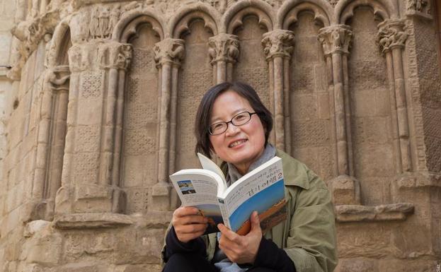 Kim Nam Hee, con su libro sobre el Camino, frente al pórtico de San Bartolomé. 