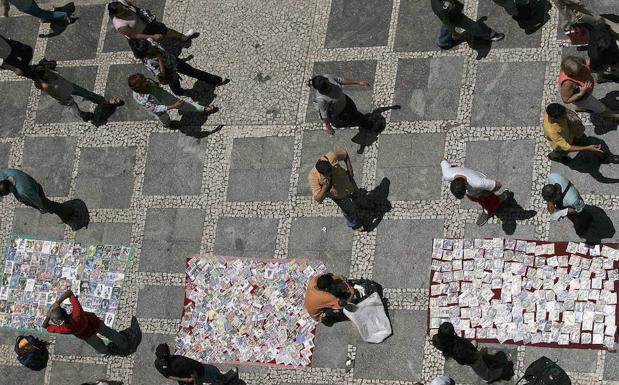 Un vendedor ambulante ofrece copias ilegales de discos compactos. 