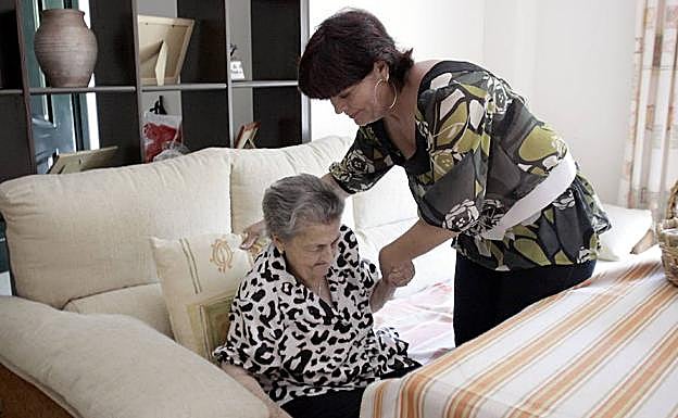 Una mujer mayor recibe cuidados en su domicilio. 
