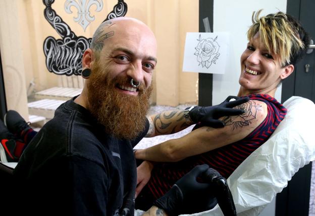 Goyo, en el estudio 'Crime Walls' de la calle Canalejas, tatuando a una clienta. :: juan marín
