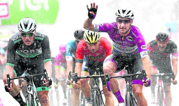 Elia Viviani entra vencedor en Iseo y muestra con la mano que es su cuarto triunfo en este Giro. :: Afp
