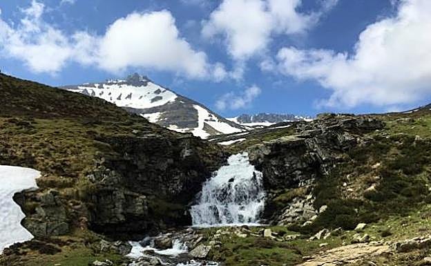 Imagen principal - Arriba, una de las primeras cascadas que forma el Urbión al pie de la cumbre. martínez . A la izquierda, la laguna, helada, bajo Peñas Claras. (Fotos David Martínez). A la derecha, David Martínez, este invierno camino del Urbión, sentado en un poste enterrado en la nieve.: