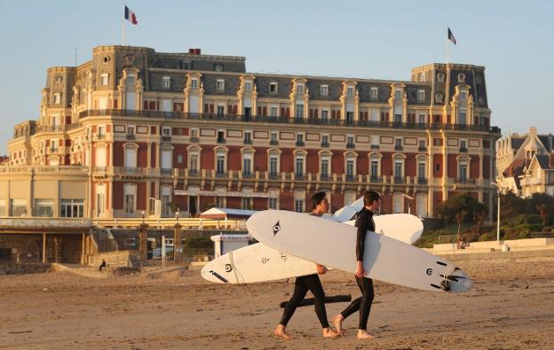 Dos surfistas caminan por la playa de Biarritz. :: lobo altuna