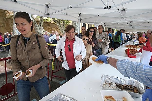 El trajín de ayer, y de cada año, en las mesas de reparto que montan los cofrades del Pez para atender a los miles de vecinos y visitantes que se acercan al Revellín. :: juan marín