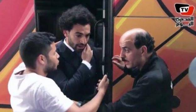 Un escolta aparta a un hincha para que no toque el hombro de Salah.