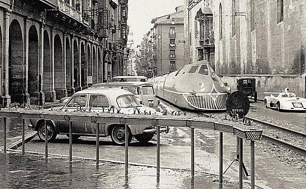 Un talgo circula por Portales con un Gordini en primer término y puede que la barqueta de Baquerín a la derecha. 