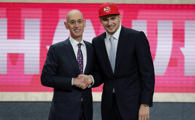 Luka Doncic (d) estrecha la mano del comisionado Adam Silver. 