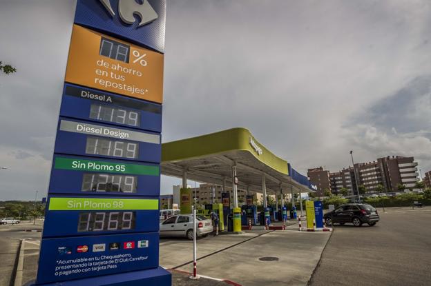 Varios conductores repostan en la estación de servicio del centro comercial Berceo de Logroño, en una imagen de ayer en la que se aprecian en primer plano los precios de los carburantes. :: justo rodríguez