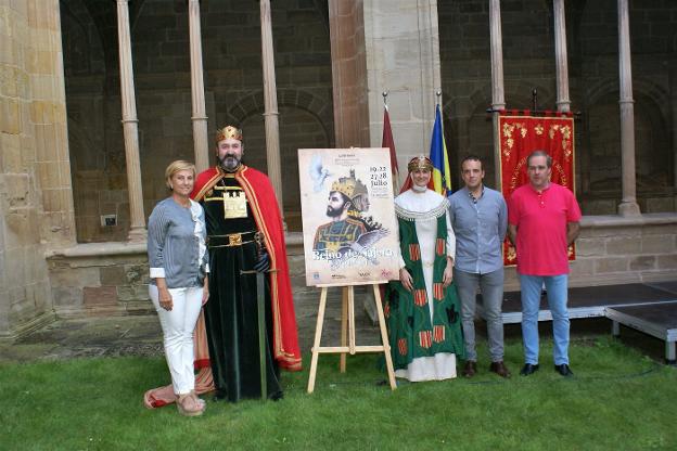 La consejera, el alcalde y el presidente de la asociación, junto a los reyes de Nájera y el cartel. :: F. D.