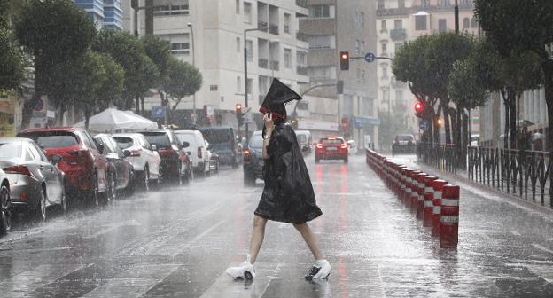 Una mujer se protege, el pasado miércoles, de la lluvia en Logroño. :: j.r.