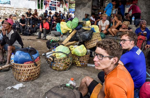 Montañeros indonesios y extranjeros descansan después de bajar ayer del volcán Rinjani, situado en la isla de Lombok. :: Ahmad Subaidi / reuters