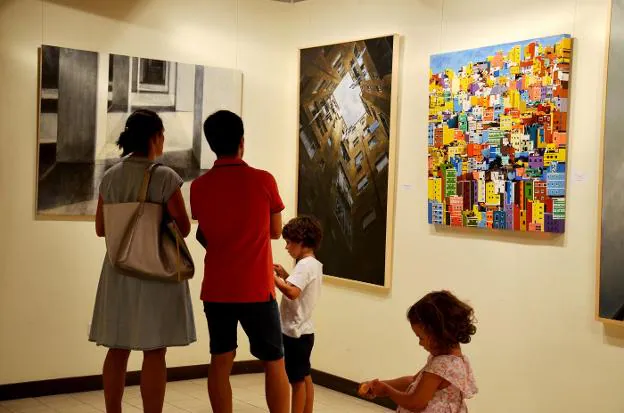 Una familia contempla uno de los cuadros premiados de  la exposición.  :: i. álvarez. 