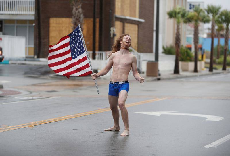Un hombre sale a la calle en ropa interior y con una bandera estadounidense a 'enfrentarse al huracán' antes de que tome tierra.