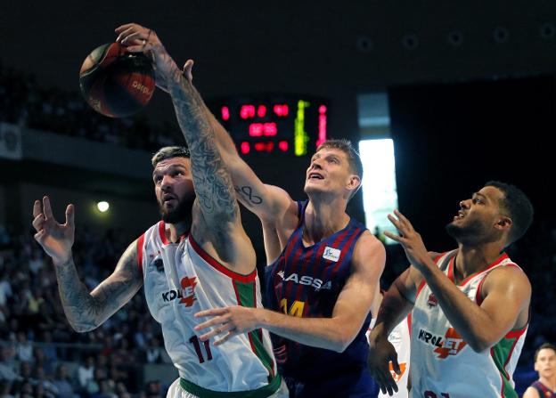 Artem Pustovny (c) pelea un balón con Matt Janning (i) y Savon Shields, del Kirolet Baskonia. :: EFE