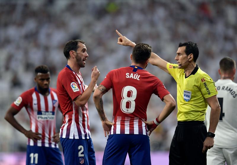 Los jugadores del Atlético protestan al árbitro.