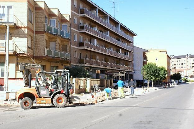 Los operarios, en pleno trabajo de construcción de la acera. :