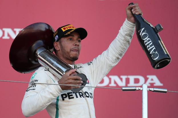 Lewis Hamilton, ayer en el podio de Suzuka celebrando el triunfo en el GP de Japón. ::  Behrouz MEHRI / Afp