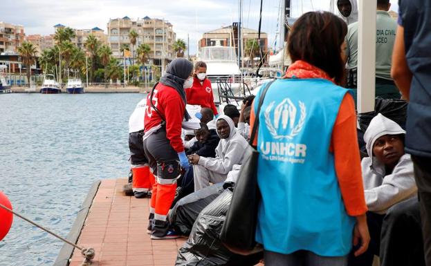 Un grupo de inmigrantes es atendido en el puerto de Melilla, tras ser recogido en el mar.