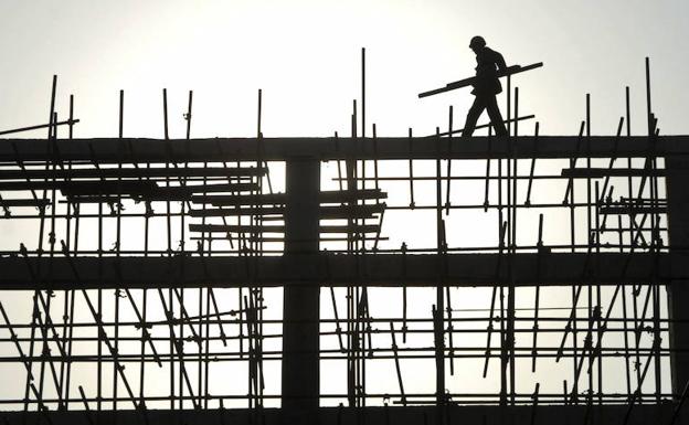 Un trabajador de la construcción porta materiales durante una obra.