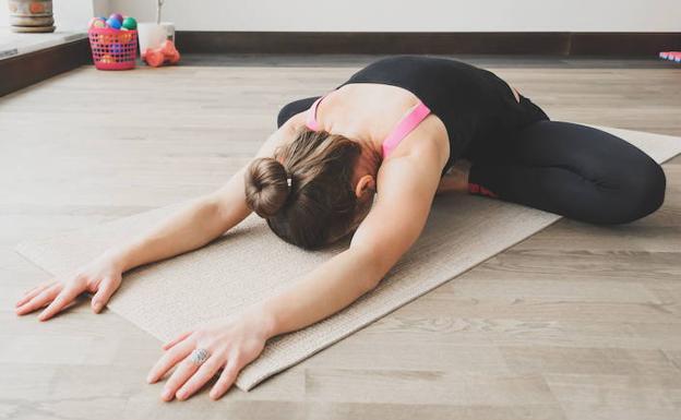 Una mujer en una clase de yoga. 