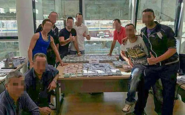 Agentes de la Policía posan con el dinero de Matutes recuperado del robo en sus oficinas de Ibiza.