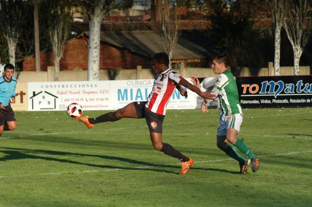 Binke, de la Sociedad Deportiva Logroñés, disputa un balón con el defensa pradejonero Adrián. 