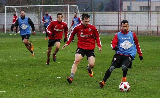 Rubén Martínez intenta controlar el balón ante la llegada de Arnedo. 
