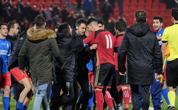 Miembros de los dos equipos se encaran tras el partido. 