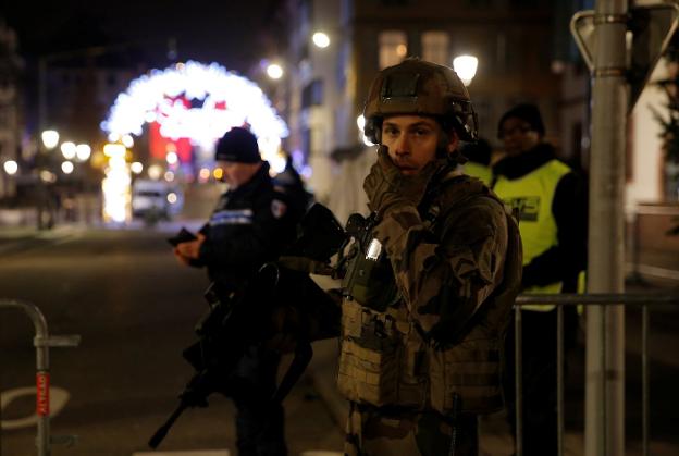 Un soldado francés vigila una calle de Estrasburgo; en la imagen inferior, los servicios de emergencia atienden a los heridos. :: reuters
