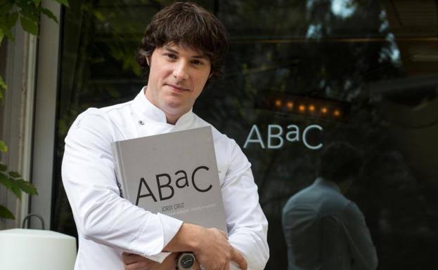 El cocinero Jordi Cruz posa junto a su nuevo libro en su restaurante barcelonés Abac.