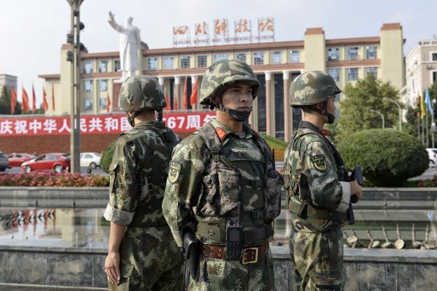 Soldados chinos montan guardia en una plaza de la ciudad de Chengdu frente a la efigie de Mao Zedong. :: z. aldama